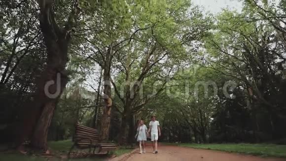 一对年轻幸福的夫妇一起在公园散步视频的预览图