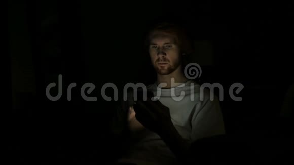 红发男子夜间使用智能手机视频的预览图