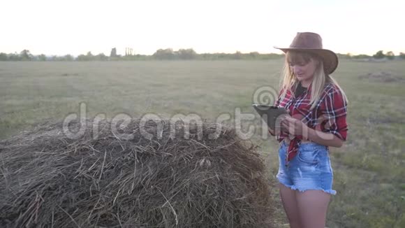 智慧农业慢动作视频概念女孩农学家在干草堆里拿着平板电脑正在学习视频的预览图