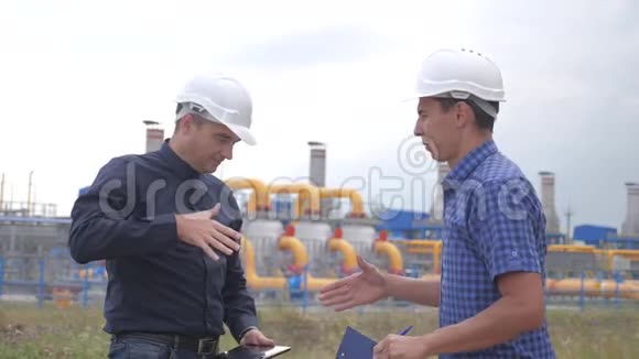 团队合作工业煤气生产站的概念慢动作视频两名戴头盔的工程师正在与视频的预览图