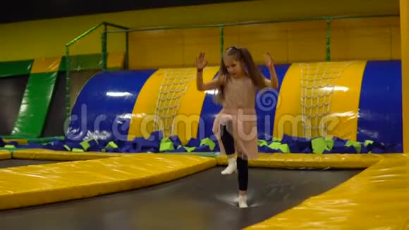 小女孩在儿童游戏室蹦床上跳视频的预览图