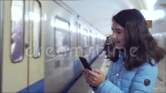 少女在地下地铁里乘地铁等待火车的到来手持智能手机一点点视频的预览图