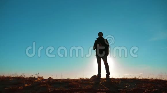 男子值得旅游与背包智能手机导航阳光站在山顶慢速视频视频的预览图