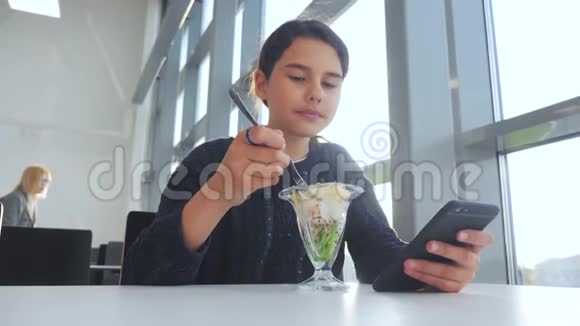 机场等待飞机航班十几岁的女孩吃沙拉生活方式看起来像智能手机在咖啡馆里上网机场视频的预览图