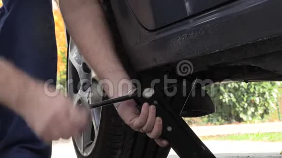 一个穿着工作裤的男人取代了汽车车轮慢动作视频的预览图