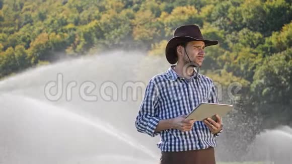 农民在监视他的种植园时使用数字平板电脑视频的预览图
