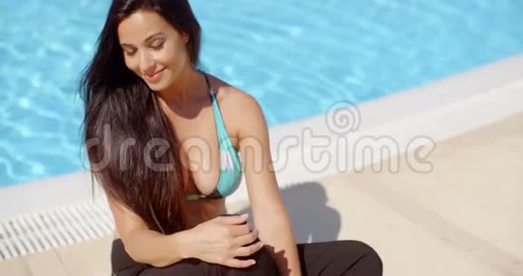 快乐的年轻女子在泳池边放松视频的预览图