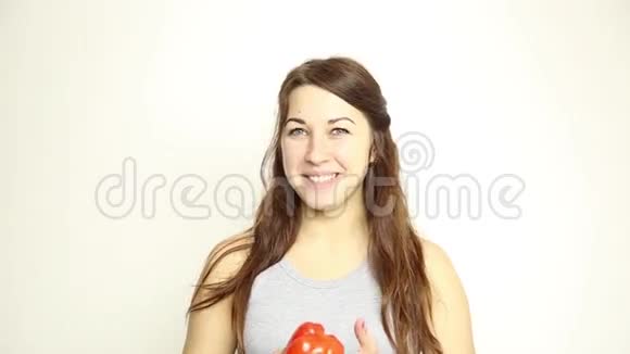 美丽的年轻女人吃蔬菜拿着红胡椒健康食物健康身体概念视频的预览图