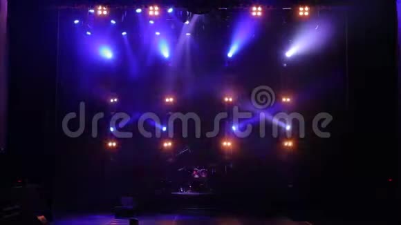 五颜六色的聚光灯在黑暗中的空音乐会舞台上带灯光的免费舞台视频的预览图