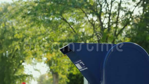 一个穿夏装的女人正在邮局附近的抽屉里扔一封信视频的预览图
