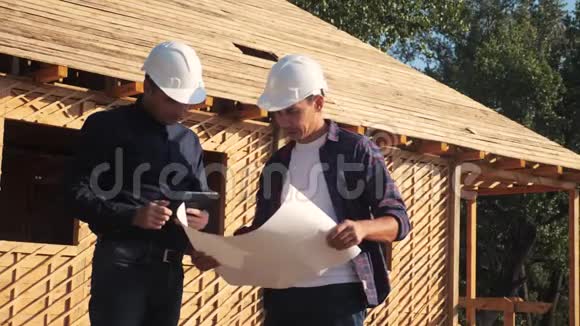 团队合作概念建设构建建筑师慢动作视频两名戴头盔的建筑工人研究房屋计划视频的预览图