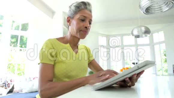 非洲裔美国妇女在家中使用数字平板视频的预览图
