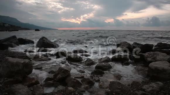 海浪围绕着海岸的石头破碎视频的预览图