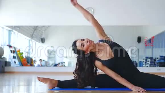 漂亮女人在垫子上训练体操的灵活性视频的预览图