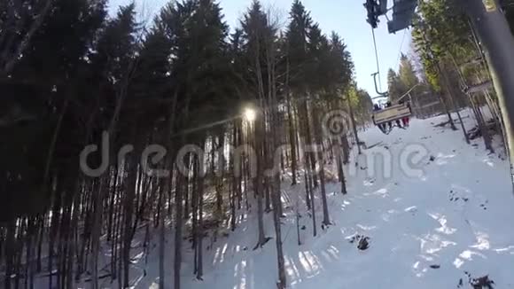 滑雪缆车载着人们上山滑雪者从雪山上下来人们在滑雪高跷板视频的预览图