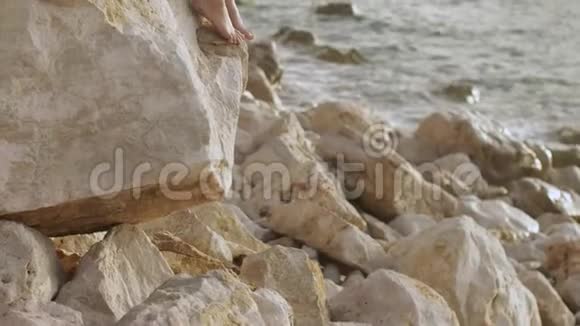 美丽的年轻女子在狂野的岩石海滩上的肖像视频的预览图