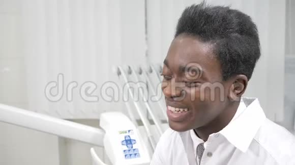 年轻的非裔美国男医生牙医在牙科诊所的椅子上有个漂亮的女病人医学卫生视频的预览图