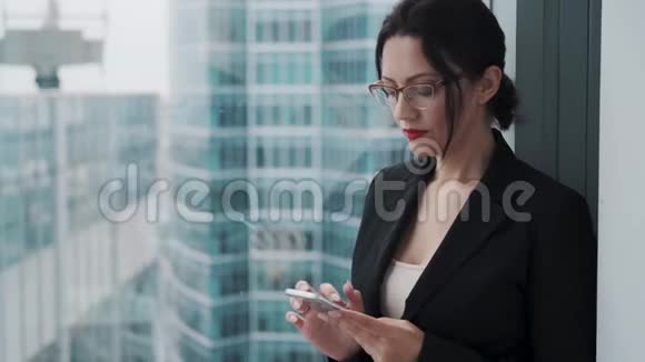 使用手机戴眼镜的女商人的肖像视频的预览图