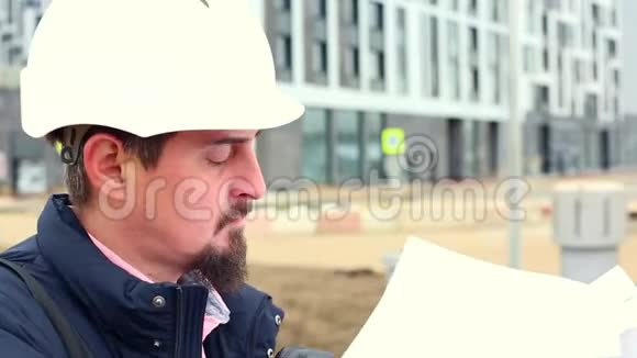 施工工程师或建筑师戴安全帽在施工现场有施工方案视频的预览图