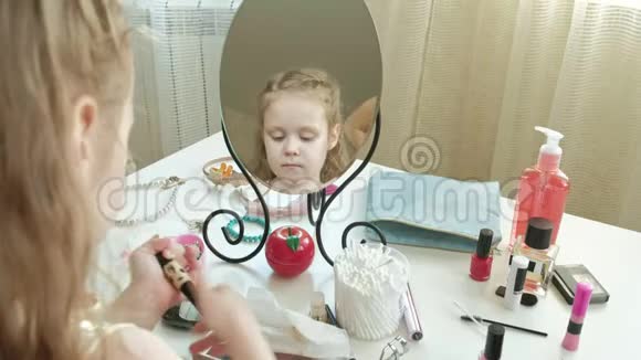 一个红头发的小女孩戴上遮瑕膏照镜子化妆脸时尚风格化妆品视频的预览图