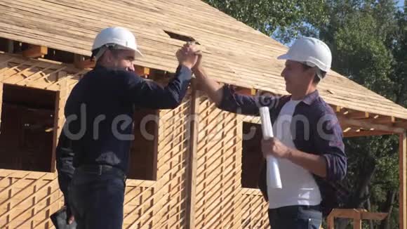 团队合作概念建设构建建筑师慢动作视频两个男人戴头盔生活方式握手视频的预览图