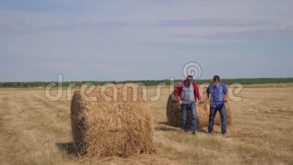 团队农业智慧农业生活方式理念两个男的农民工人走在田野的干草堆上视频的预览图