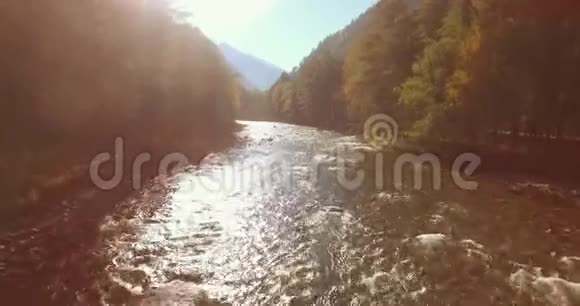 在阳光明媚的夏季早晨低空飞行在带岩石的新鲜快山河上视频的预览图