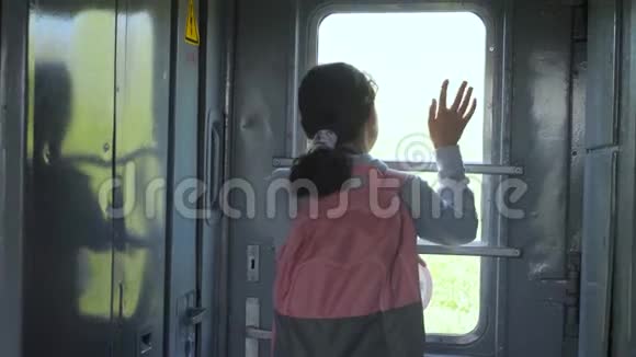 小女孩是乘火车旅行的背包客旅游运输铁路概念旅游学校的女孩视频的预览图