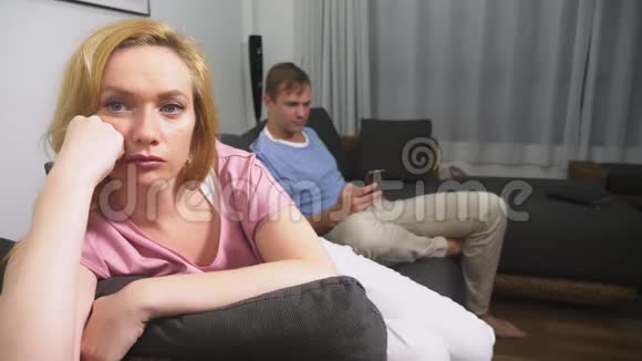 两次危机男人和女人在客厅沙发上过夜男人用电话女人是视频的预览图