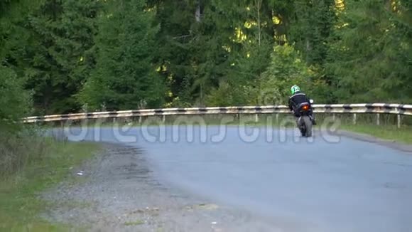 一个骑摩托车的人年轻的帅哥骑摩托车在山路上视频的预览图