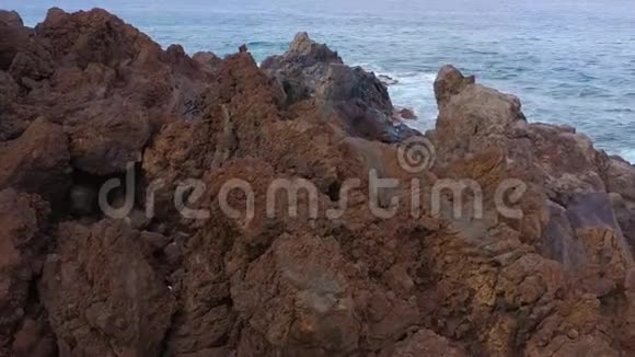 特内里费岛的岩石海岸空中无人机的海浪到达海岸的画面视频的预览图