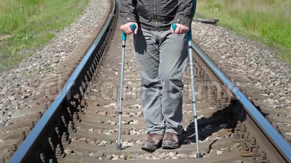在铁路上拄拐杖的残疾人视频的预览图
