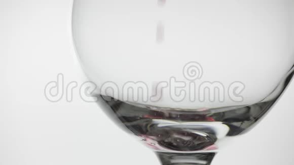 玫瑰酒红酒倒在白色背景上的酒杯里慢动作视频的预览图