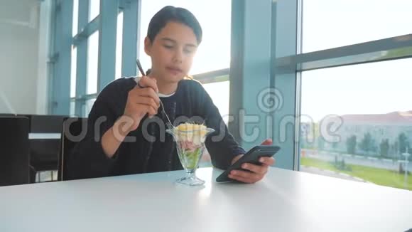 机场等待飞机航班十几岁的女孩吃沙拉看上去像智能手机在咖啡馆里上网机场航站楼视频的预览图