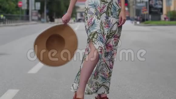 美丽的金发女郎戴着帽子在城市里走来走去慢动作视频的预览图