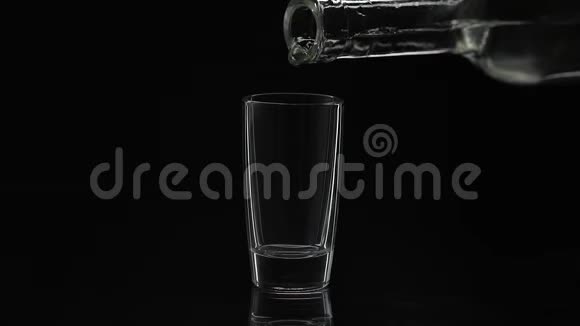 把一瓶伏特加倒入玻璃杯里黑色背景视频的预览图