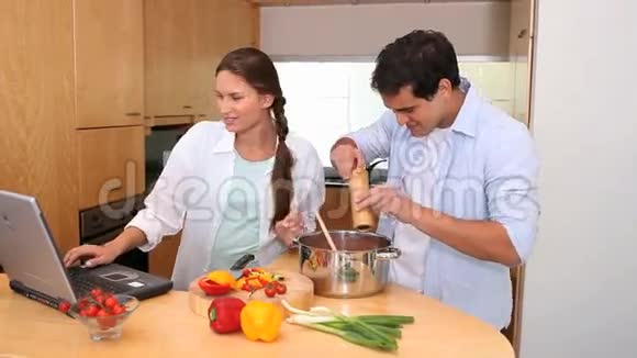 一对夫妇用笔记本电脑一起做饭视频的预览图