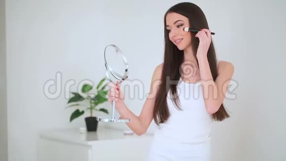 美丽的面部护理年轻女子的肖像她的皮肤上涂满了奶油视频的预览图