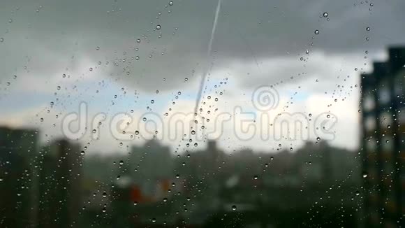 在暴风雨的一天里城市的雨滴落在窗户上背景下的城市天际线视频的预览图