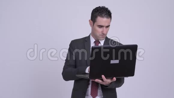 快乐英俊的商人思考笔记本电脑视频的预览图