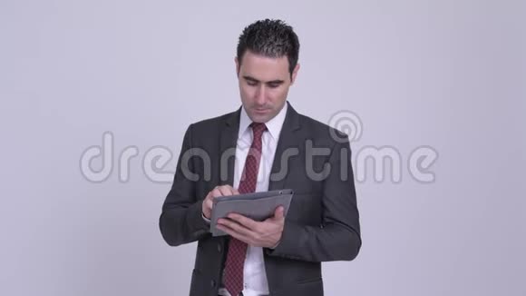 快乐英俊的商人用数码平板电脑思考视频的预览图