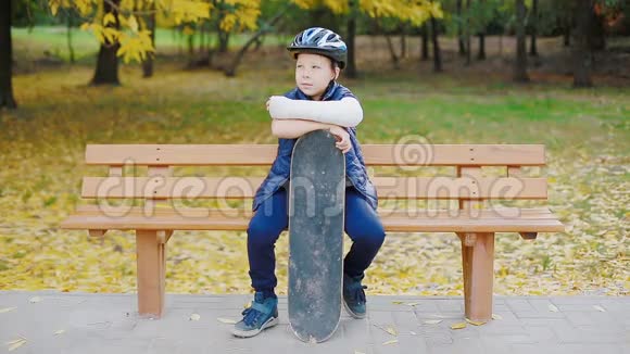 一个手臂骨折的白人男孩坐在溜冰场视频的预览图