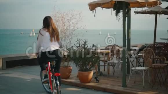 夏天骑自行车的女人在海滩上视频的预览图