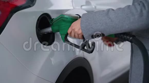 在加油站的一个特写镜头里女人往车里灌汽油视频的预览图