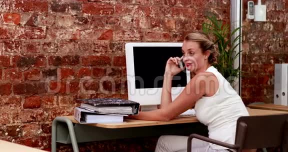 随便的女商人在她的智能手机上说话视频的预览图