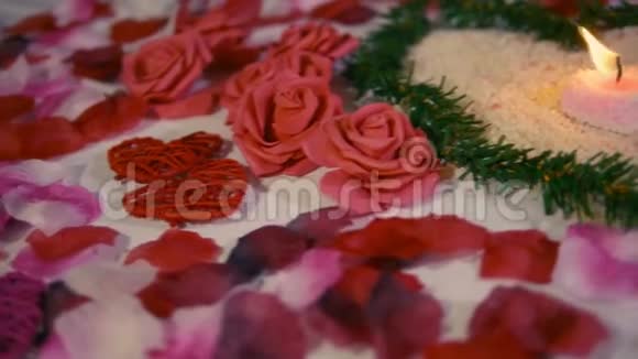 情人节惊喜与装饰花玫瑰花瓣和蜡烛燃烧镜头视频的预览图