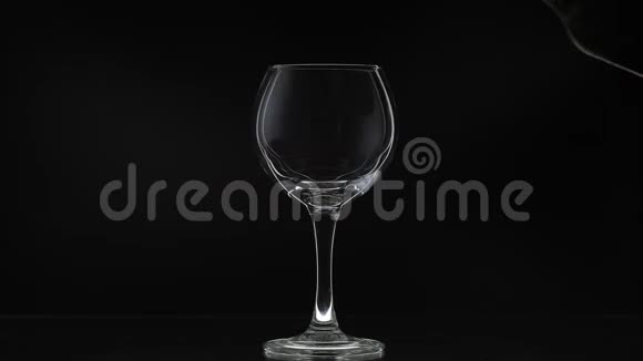 玫瑰酒红酒倒在黑色背景上的酒杯里慢动作视频的预览图