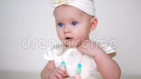 穿白色连衣裙戴头巾的女婴视频的预览图