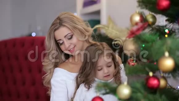 快乐的妈妈和小女儿靠近圣诞树视频的预览图