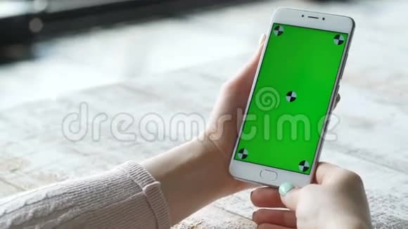 年轻女性使用绿色屏幕智能手机视频的预览图